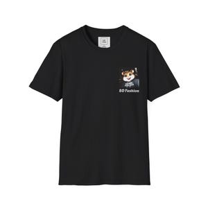 May include: A black short-sleeved t-shirt featuring a graphic on the left chest area. The graphic depicts a cartoon hamster wearing a hoodie with the text GAME DEVELOPER printed on it. Below the hamster, the text BD FASHION is printed in white.