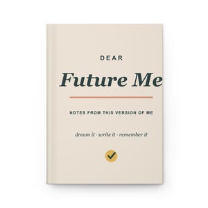 Może przedstawiać: Kremowy dziennik z nadrukowanym czarnym tekstem DEAR Future Me, NOTES FROM THIS VERSION OF ME oraz dream it · write it · remember it. Pozioma pomarańczowa linia oddziela tekst, a poniżej znajduje się żółte koło z czarnym znakiem zaznaczenia.