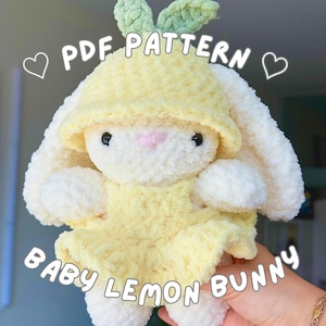 May include: A handmade, plush bunny toy dressed as a lemon. The bunny is white with a yellow dress and hat, and green leaf details. The text "PDF PATTERN" and "BABY LEMON BUNNY" are visible on the image.