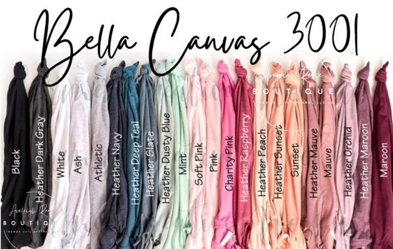 May include: A collection of Bella Canvas 3001 t-shirts displayed in a row, featuring a wide spectrum of colours including black, grey, white, blue, teal, mint, pink, peach, and maroon, with each shirt labelled by its specific colour name.