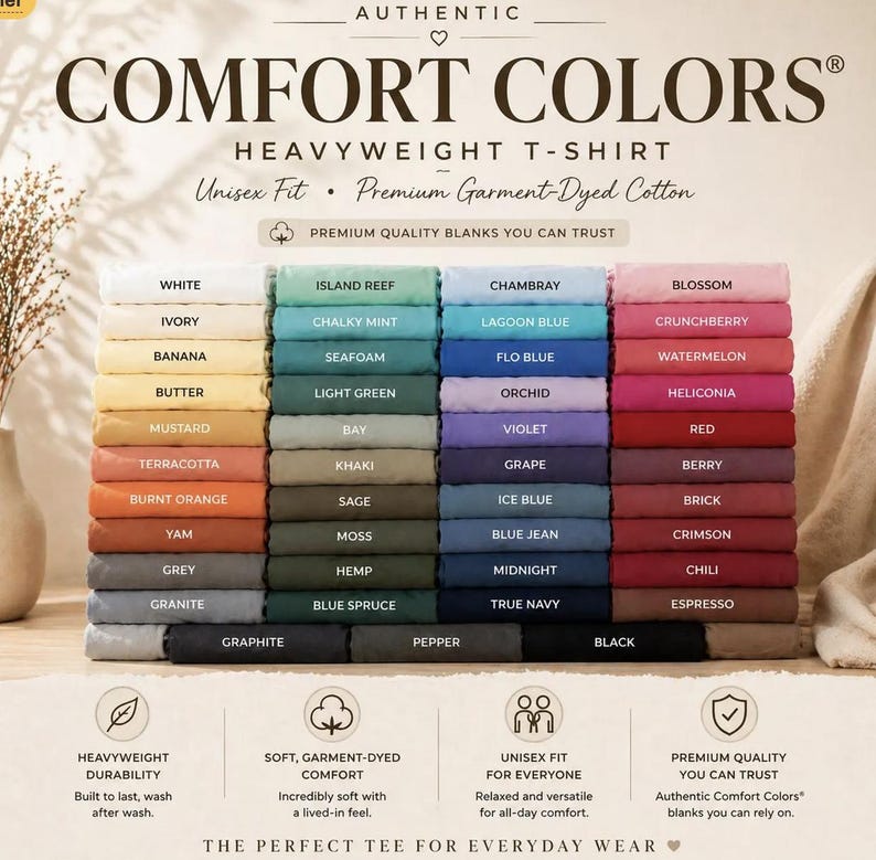 May include: A display of folded Comfort Colors heavyweight t-shirts in various colors, including white, blue, and pink. The image features the brand's logo and text, highlighting the unisex fit and garment-dyed cotton material.