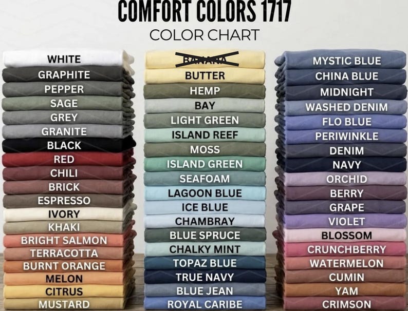 May include: A color chart for Comfort Colors 1717, displaying a variety of folded t-shirts in various colors. The chart includes colors like white, black, red, blue, and green, with the names of the colors printed above each stack of shirts.