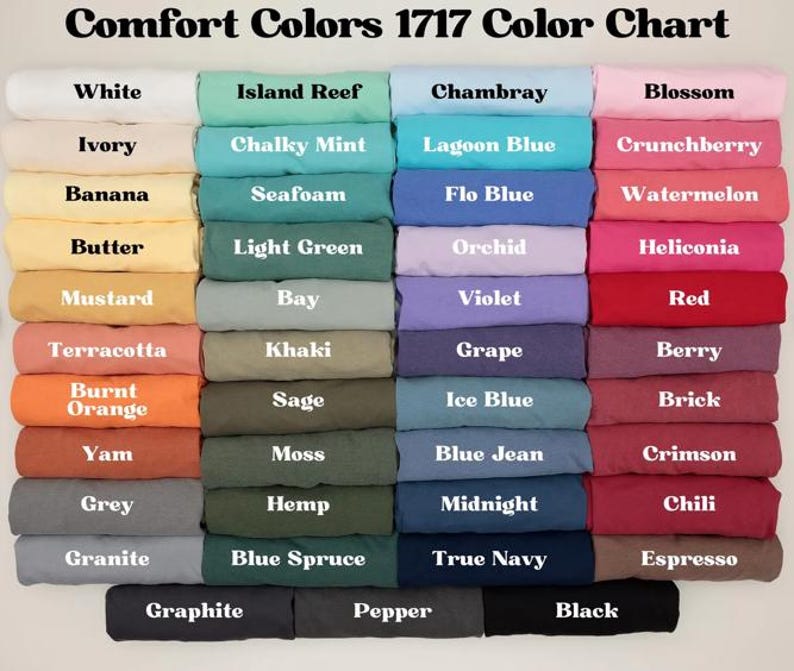 May include: A color chart displaying a variety of Comfort Colors 1717 fabric swatches. The chart features a wide range of colors, including white, ivory, banana, butter, mustard, terracotta, burnt orange, yam, grey, granite, island reef, chalky mint, seafoam, light green, bay, khaki, sage, moss, hemp, blue spruce, chambray, lagoon blue, flo blue, orchid, violet, grape, ice blue, blue jean, midnight, true navy, blossom, crunchberry, watermelon, heliconia, red, berry, brick, crimson, chili, espresso, graphite, pepper, and black.