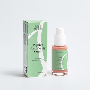 Puede incluir: Una caja verde claro y un frasco de suero rosa con una bomba blanca. Tanto la caja como el frasco presentan el texto "RICCO MILANO Peptide Anti-Aging Serum". El suero está diseñado para suavizar y reducir las líneas finas. El frasco contiene 30 ml / 1,01 fl oz.