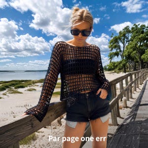 Peut inclure: Un pull à manches longues en crochet noir avec un motif à larges mailles, porté sur un haut bandeau noir, associé à un short en jean noir. Le texte "Par page one err" est visible en bas de l'image. Le pull présente un design à mailles ouvertes.