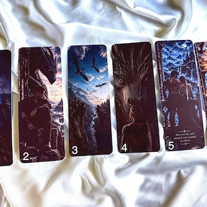 May include: Six rectangular bookmarks featuring fantasy illustrations of dragons, landscapes, and human figures. Bookmark 2 includes text, and bookmark 5 features the text: 'You were the only storm I ever wanted to chase.' Each bookmark is numbered 1 through 6.