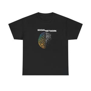Op de afbeelding: Zwart t-shirt met de tekst "SOCIAL NETWORK" boven een hersengrafiek. De linkerkant van de hersenen is kleurrijk, terwijl de rechterkant grijs is, wat een visueel contrast creëert.