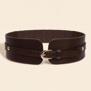 May include: A wide dark brown elasticized waist belt featuring a smooth faux leather front panel, a gold-toned metal buckle, and two gold-toned metal studs on each side. The belt has a textured finish and a secure adjustable prong closure.