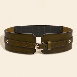 May include: A wide olive green waist belt featuring a smooth finish, a central silver-toned metal buckle, and two silver-toned metal studs on each side. The interior of the belt is lined with a dark grey fabric, and the strap includes multiple adjustment holes.