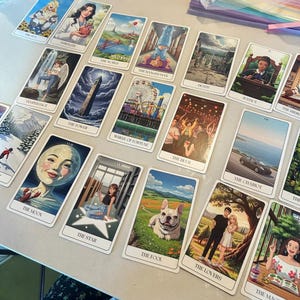 Puede incluir: Una colección de cartas del tarot con varias ilustraciones y títulos. Las cartas presentan imágenes como El Sol, La Fuerza, El Mundo, El Colgado, La Muerte, La Justicia, Templanza, La Torre, Rueda de la Fortuna, El Diablo, El Carro, La Luna, La Estrella, El Loco y Los Amantes.