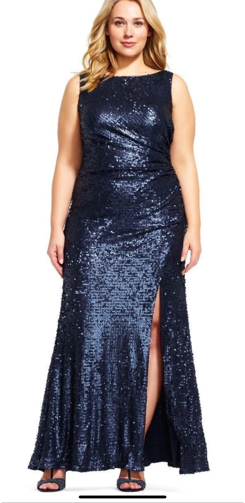 May include: A sleeveless, navy blue sequin gown with a high slit. The dress has a fitted bodice and a flowing skirt. The model is wearing black sandals. The dress is suitable for formal events.
