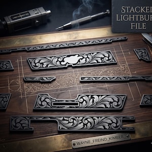 May include: An assortment of intricately engraved metal components with a floral scroll design, arranged on a wooden surface. The pieces are black with silver detailing. The text "STACKED LIGHTBURN FILE" is visible. A metal nameplate reads "WAYNE_FREIND_KIMBER_".