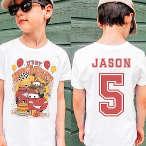 May include: White t-shirt with a colorful graphic featuring a red race car, birthday cake, and the text "It's My Birthday". The back of the shirt displays the name "Jason" and the number "5" in red.