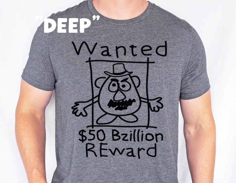 K&ouml;nnte beinhalten: Graues T-Shirt mit einer schwarzen Cartoon-Illustration eines kartoffelartigen Charakters in einem Fahndungsplakat. Der Text auf dem Shirt lautet "DEEP", "Wanted", "$50 Bzillion REWARD".