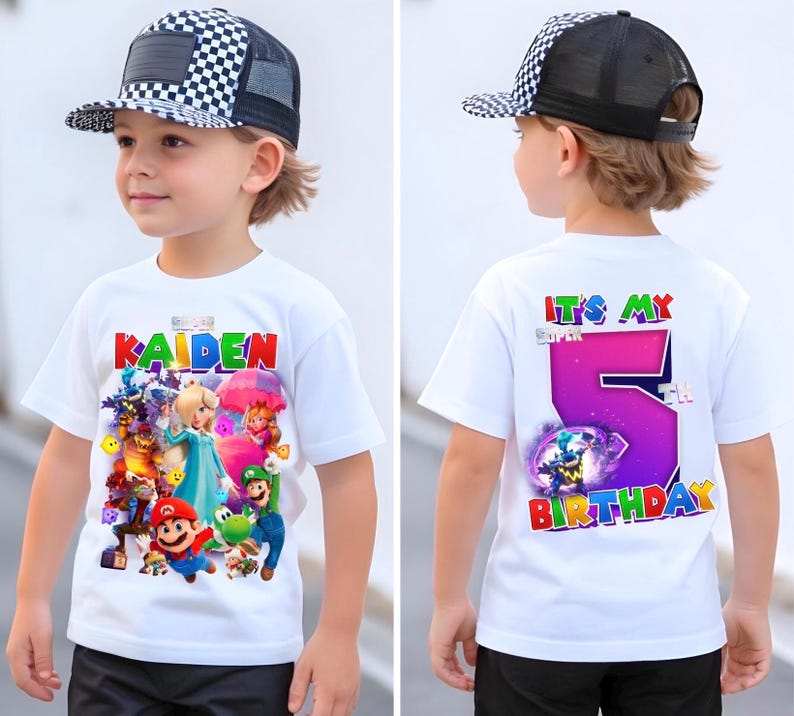 May include: A white t-shirt with a vibrant graphic of video game characters and the name "KAIDEN" in red, blue, and green. The back of the shirt says "IT'S MY SUPER 5TH BIRTHDAY" with a large purple number 5. The child is wearing a black and white checkered cap.