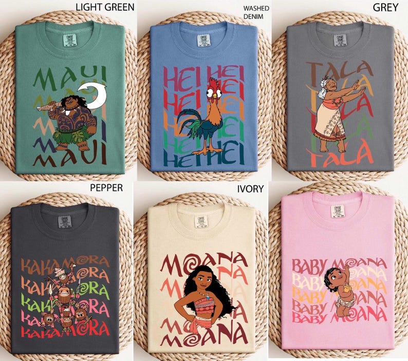 May include: Six different t-shirts in various colors, each featuring a cartoon character and text. Colors include light green, blue, grey, dark grey, ivory, and pink. The shirts have round necks and short sleeves. The text and graphics are in a colorful, cartoon style.