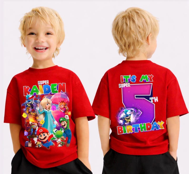 May include: Red t-shirt with a colourful graphic of video game characters and the name "Kaiden" in white. The back of the shirt says "It's My 5th Birthday" in colourful text. The shirt is short-sleeved.