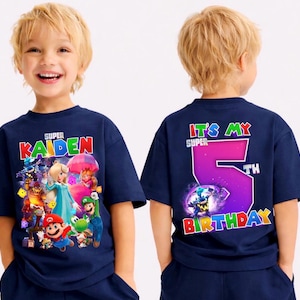 May include: Navy blue t-shirt with a Super Mario graphic and the name "KAIDEN" on the front. The back of the shirt says "IT'S MY SUPER 5TH BIRTHDAY" in bright colours. A fun birthday-themed tee.