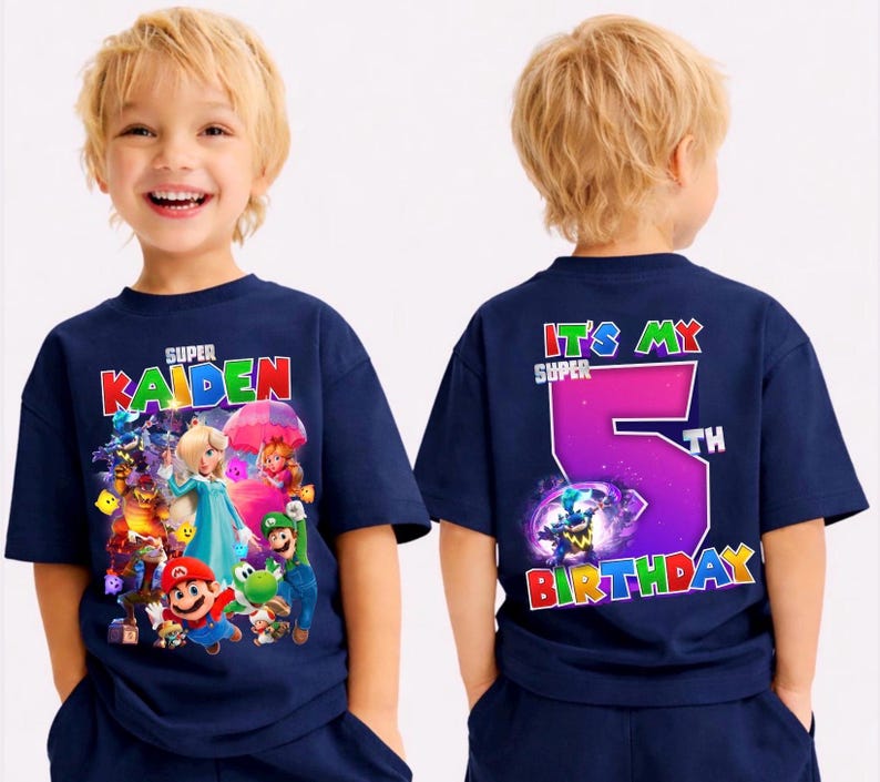May include: Navy blue t-shirt with a Super Mario graphic and the name "KAIDEN" on the front. The back of the shirt says "IT'S MY SUPER 5TH BIRTHDAY" in bright colours. A fun birthday-themed tee.