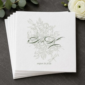May include: A stack of square white paper cards featuring a light green botanical line drawing of flowers and dragonflies. In the center, dark green cursive letters M and K are joined by a plus sign. The date august 26, 2026 is printed below.