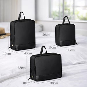 May include: Three black travel bags of varying sizes are displayed. The largest bag is 15.7 inches wide, 11.8 inches tall, and 3.9 inches deep. The medium bag is 11.8 inches wide, 7.9 inches tall, and 3.9 inches deep. The smallest bag is 11.8 inches wide, 7.9 inches tall, and 3.9 inches deep.