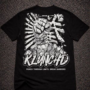 May include: A black t-shirt featuring a white graphic of a wrapped fist punching through a surface. The design includes Japanese characters, the text KLUNCHD, and the phrase PUNCH THROUGH LIMITS, BREAK BARRIERS printed in a bold, white font.