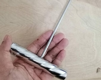 May include: A silver-colored metal T-handle tool featuring a cylindrical grip with a spiraled, reflective surface and a long, thin, pointed metal spike extending perpendicularly from the center of the handle for piercing or probing tasks.
