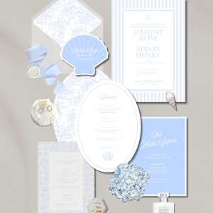May include: A collection of light blue and white wedding stationery, including invitations, RSVP cards, and details cards. The design features floral patterns, stripes, and seashell motifs. A bouquet of blue hydrangeas and a bottle of perfume are also included.