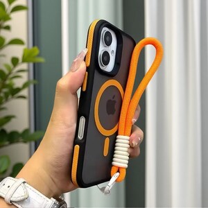 May include: Black and orange phone case with a matching orange lanyard. The case has an orange circle and a vertical stripe. The lanyard is attached with a white and silver clasp.