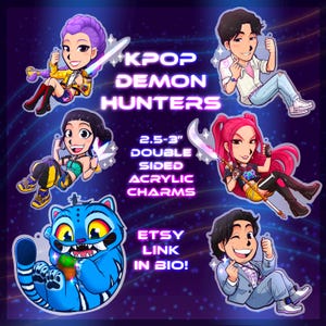 May include: Double-sided acrylic charms featuring KPOP Demon Hunters. The image shows six cartoon characters with swords and a blue tiger-like creature. Text on the image reads "KPOP DEMON HUNTERS" and "2.5-3" DOUBLE SIDED ACRYLIC CHARMS".