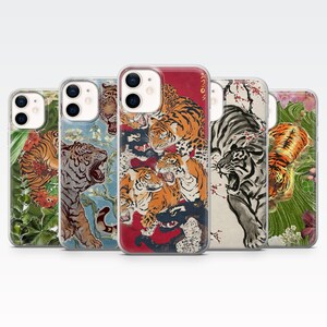 Pode incluir: Cinco capas de telemóvel com designs de tigres. Os designs apresentam ilustrações de tigres em diferentes estilos e ambientes. A paleta de cores inclui laranja, preto, branco e elementos florais. As capas são para um telemóvel.