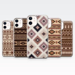 May include: Five phone cases with geometric patterns inspired by the American Southwest. The cases display various designs in brown, beige, and muted tones, including diamonds, zigzags, and tribal motifs. The cases are made of a clear material.