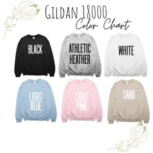 May include: A color chart of Gildan 18000 sweatshirts in various colors, including black, athletic heather, white, light blue, light pink, and sand. Each sweatshirt displays its color name in bold, white text.