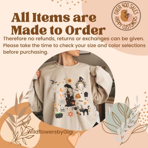 May include: Beige sweatshirt with a colorful Halloween-themed graphic. The design includes a haunted house, a black cat, a witch, a skeleton, and other spooky elements. Text on the image reads "All Items are Made to Order" and "Over 400 Sales Happy Customers".