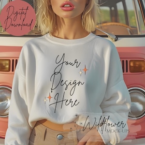 May include: White cropped sweatshirt with the text "Your Design Here" in black script. The sweatshirt is worn by a model standing in front of a vintage van.