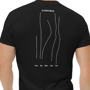Puede incluir: Camiseta negra con un dibujo lineal blanco en la espalda. El dibujo incluye líneas verticales y formas curvas, con el texto "IT/ARC/M-B" arriba y números abajo. Una camiseta informal para el uso diario.