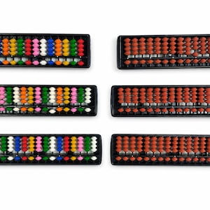 May include: Six rectangular abacus frames with black plastic borders. Three frames feature rows of multi-colored beads in white, yellow, orange, green, pink, and blue. Three frames feature rows of uniform brown beads arranged in a grid pattern.
