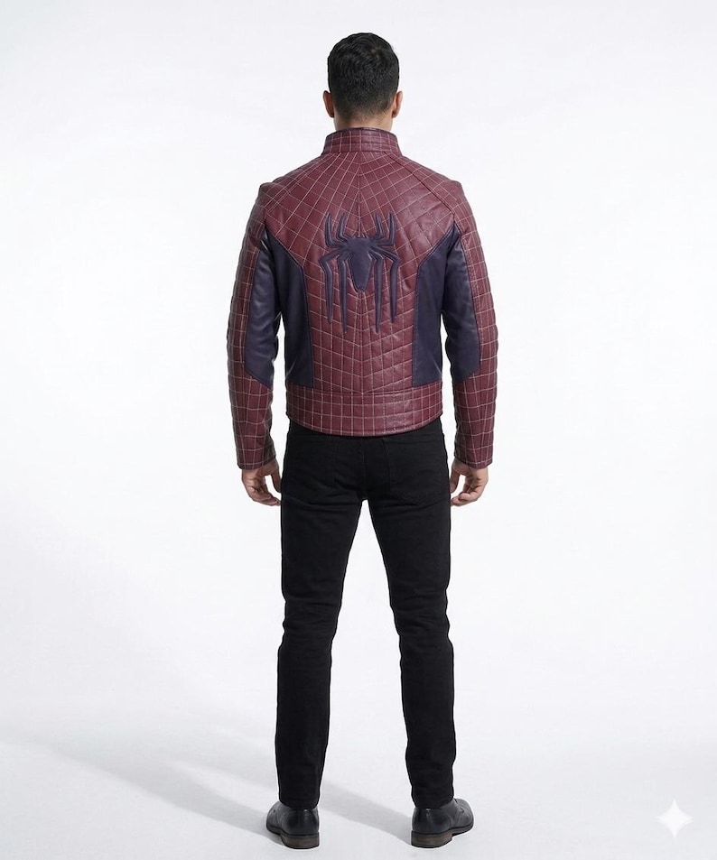 Peut inclure: Une veste bordeaux et bleu fonc&eacute; avec un motif quadrill&eacute; matelass&eacute; et un embl&egrave;me d'araign&eacute;e sombre bien visible dans le dos. La veste pr&eacute;sente un col montant et des manches longues, port&eacute;e avec un pantalon noir et des chaussures noires.