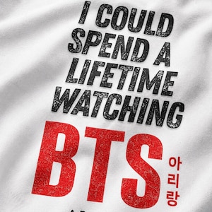 Peut inclure: Sweat-shirt blanc avec l'inscription "I COULD SPEND A LIFETIME WATCHING BTS" en noir, avec un effet vieilli. Le mot "BTS" est en grandes lettres rouges, &eacute;galement avec un effet vieilli. En dessous, le texte "ARIRANG WORLD TOUR" est imprim&eacute; en rouge.
