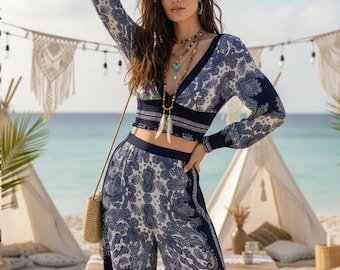 May include: A two-piece set consisting of a long-sleeved cropped top and wide-leg pants, both featuring a dark blue and white paisley pattern. The top has a deep V-neckline and a fitted waistband, while the pants have a high-waisted fit.