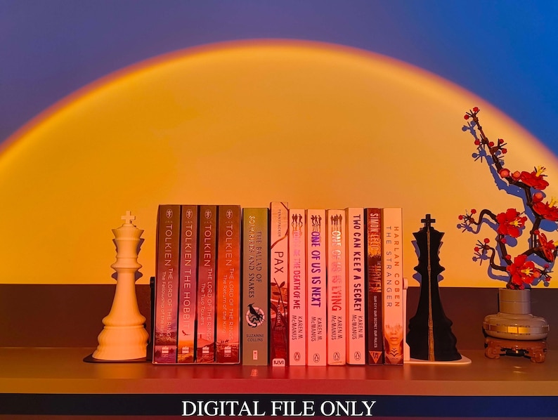 May include: A shelf displays a collection of books, including titles by Tolkien and Harlan Coben, alongside chess pieces and a decorative floral arrangement. The text "DIGITAL FILE ONLY" is at the bottom.