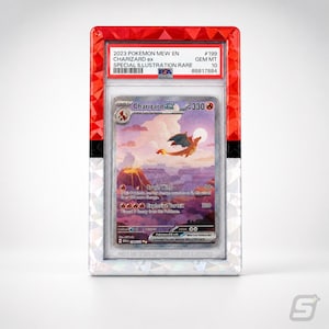 May include: A graded Charizard ex Pokémon card in a protective case. The card features a vibrant illustration of Charizard flying over a volcano. The case has a red and white geometric design with the text "2023 POKEMON MEW EN CHARIZARD ex SPECIAL ILLUSTRATION RARE".