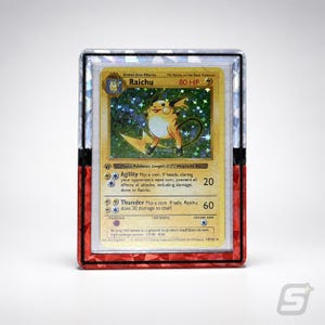 May include: A Raichu Pokémon card in a protective case. The card features a yellow and brown Raichu illustration with text including "Raichu" and "80 HP". The case has a red and black border.