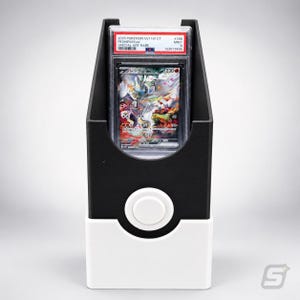 May include: A black and white plastic display stand featuring a circular button design on the front. Inside the stand is a graded trading card in a clear plastic slab labeled 2025 POKEMON SV11W CT RESHIRAM EX #168 MINT 9.