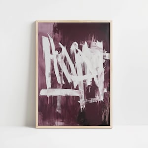 May include: Abstract art print in a wooden frame. The artwork features bold white brushstrokes against a deep burgundy background. The white paint appears to drip in areas, creating a dynamic and textured effect. The piece is framed in a natural wood.