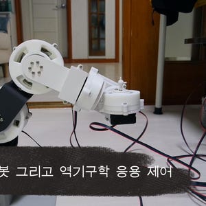 Peut inclure: Un bras robotique blanc et noir avec plusieurs articulations et des boîtiers de moteur circulaires. Le bras présente des câbles exposés et porte le texte coréen DIY 6축 로봇 그리고 역기구학 응용 제어, signifiant Robot 6 axes DIY et contrôle d'application par cinématique inverse.