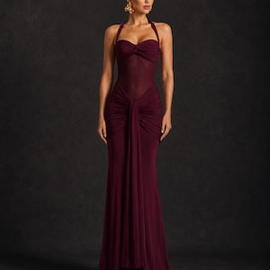 May include: A burgundy halter-neck gown with a fitted bodice and a flowing skirt. The dress features a gathered knot detail at the waist and a sheer panel on the upper bodice. The elegant design is suitable for formal events.