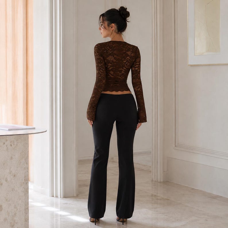 May include: A long-sleeved brown lace top with a scalloped hem paired with solid black flared trousers. The top features a fitted silhouette with intricate floral lace patterns, while the trousers have a smooth finish and a full-length cut.