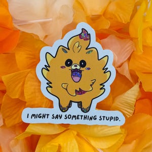 May include: A sticker featuring a cartoon Pomeranian with a surprised expression and a colorful tongue. The sticker is yellow with a white border and the text "I MIGHT SAY SOMETHING STUPID" at the bottom. The background is orange.