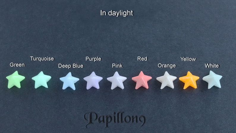 May include: A collection of star-shaped beads in various colors, including green, turquoise, deep blue, purple, pink, red, orange, yellow, and white. The image includes the text "In daylight" and the brand name "Papillong".